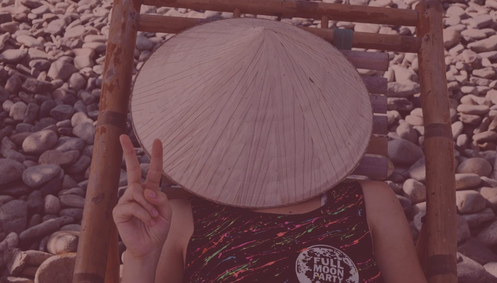woman coworking space member in a round hat lying on a bamboo lounge